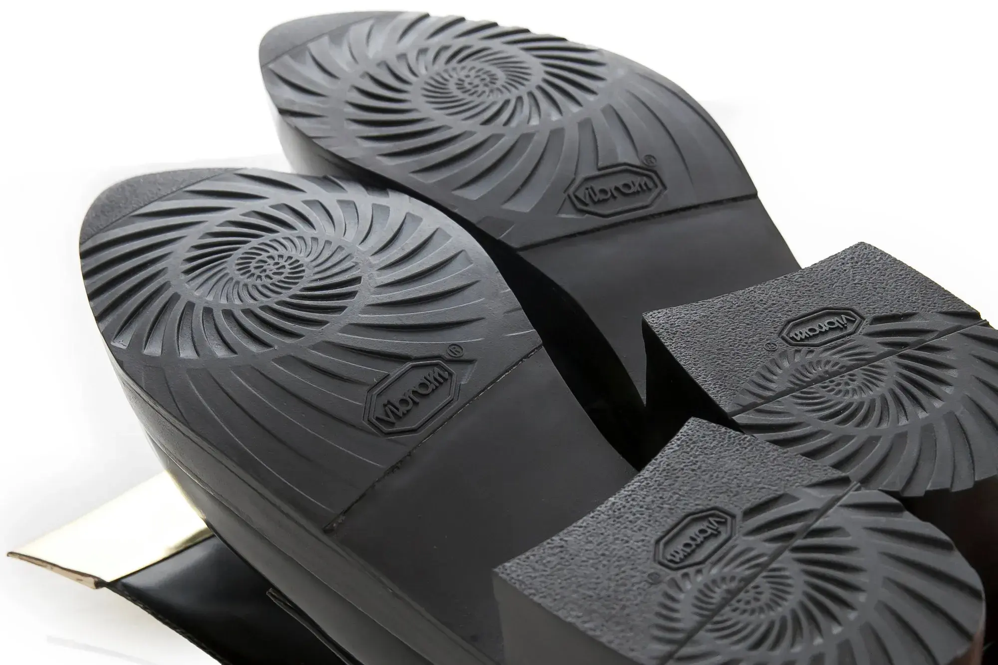 The soles of the black patent derbies
