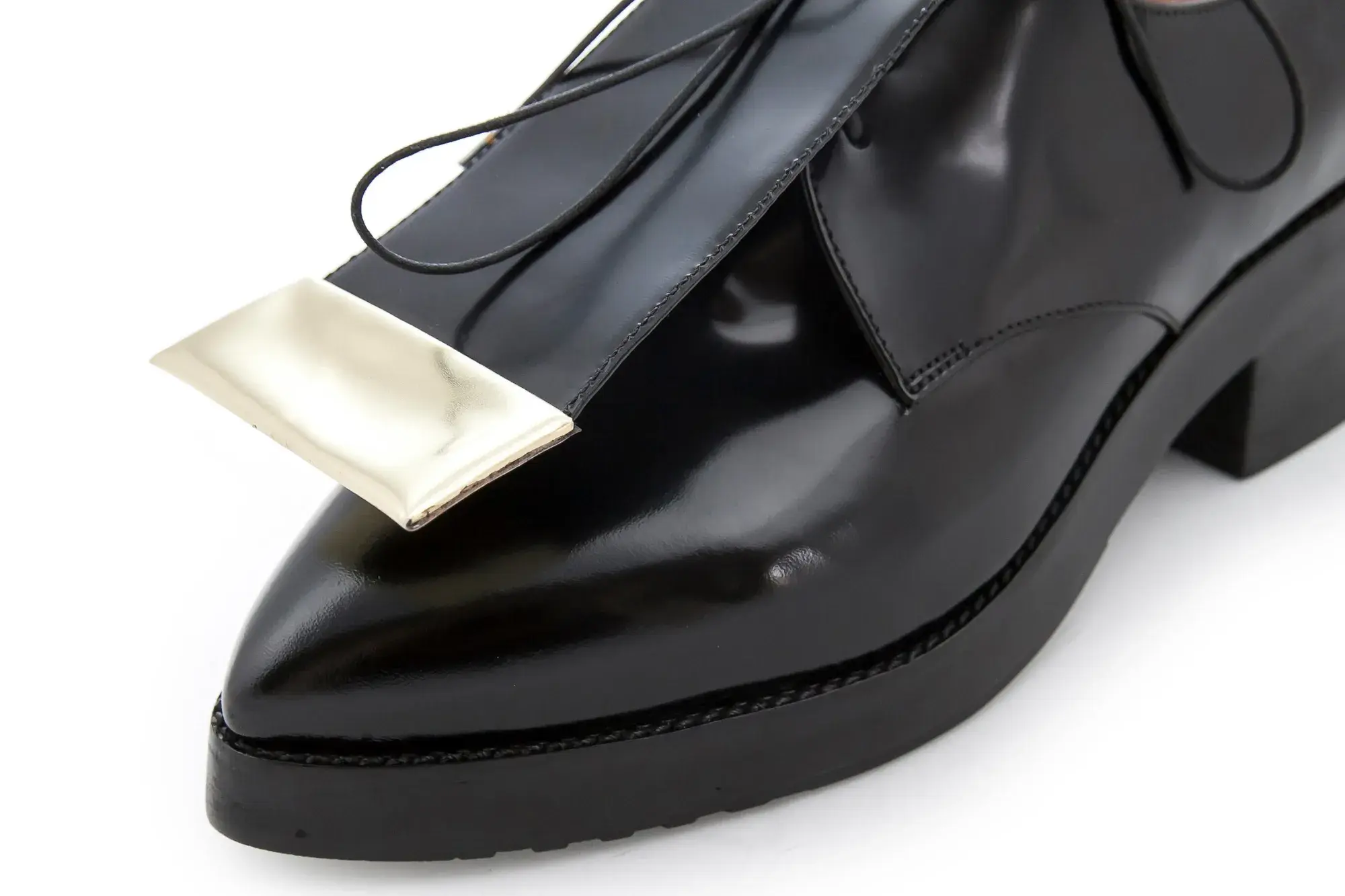 Toe detail of a black patent derby