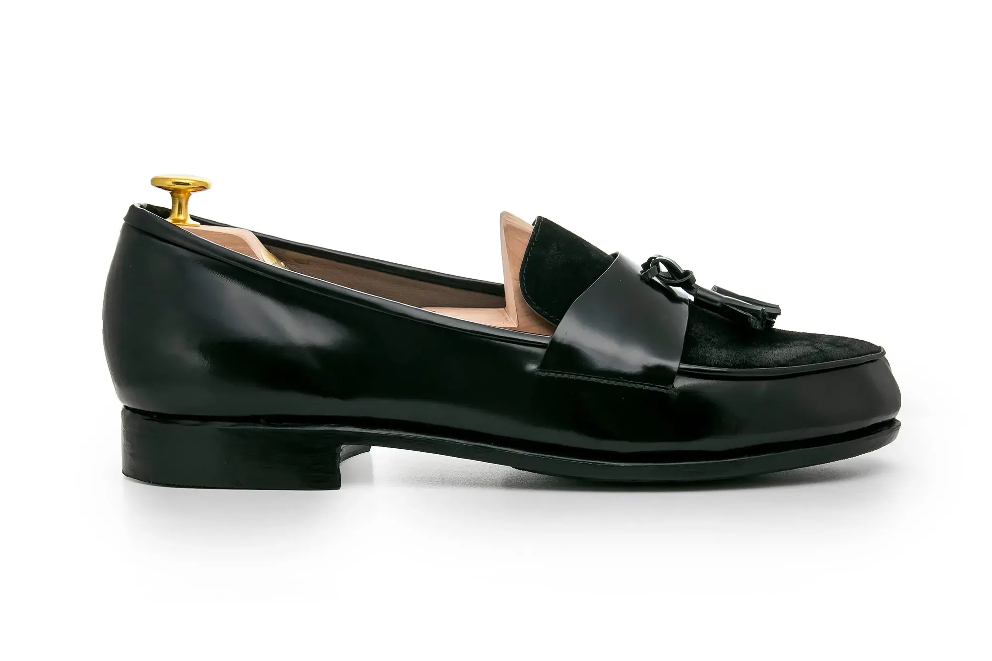 A black tassel loafer in profile