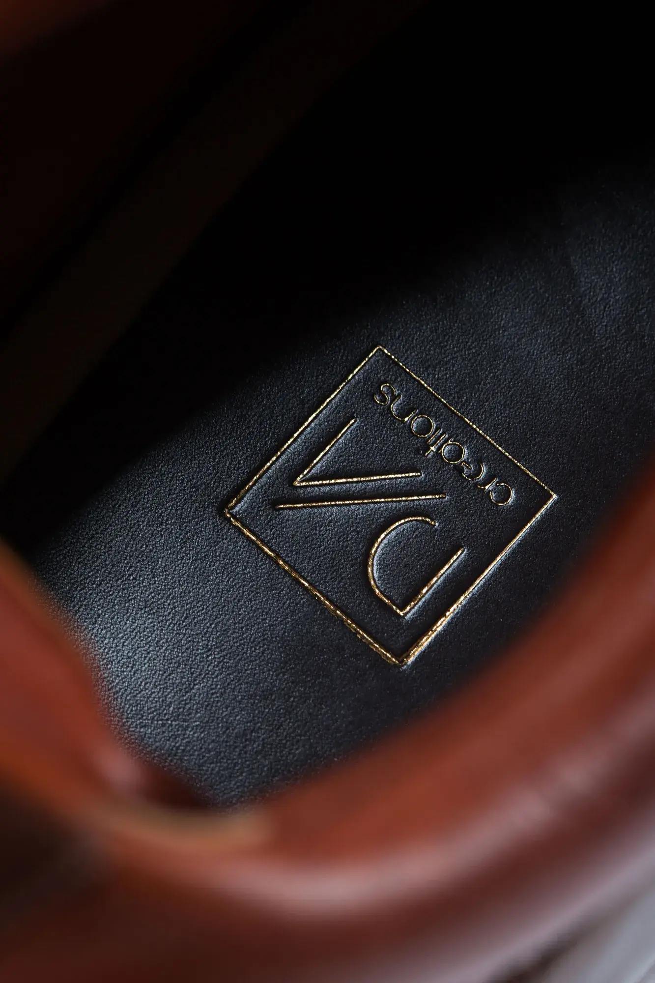 Logo detail of a chestnut lace-up