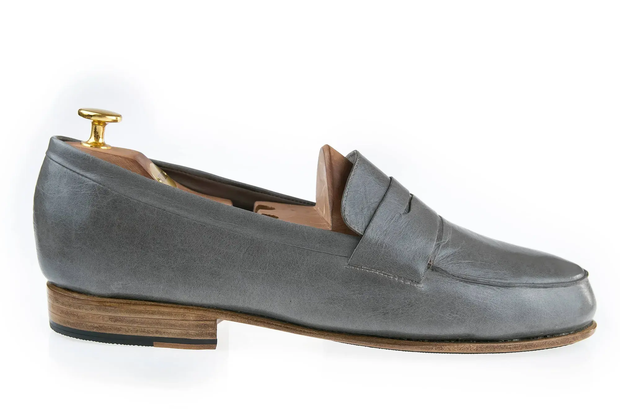 A grey penny loafer in profile