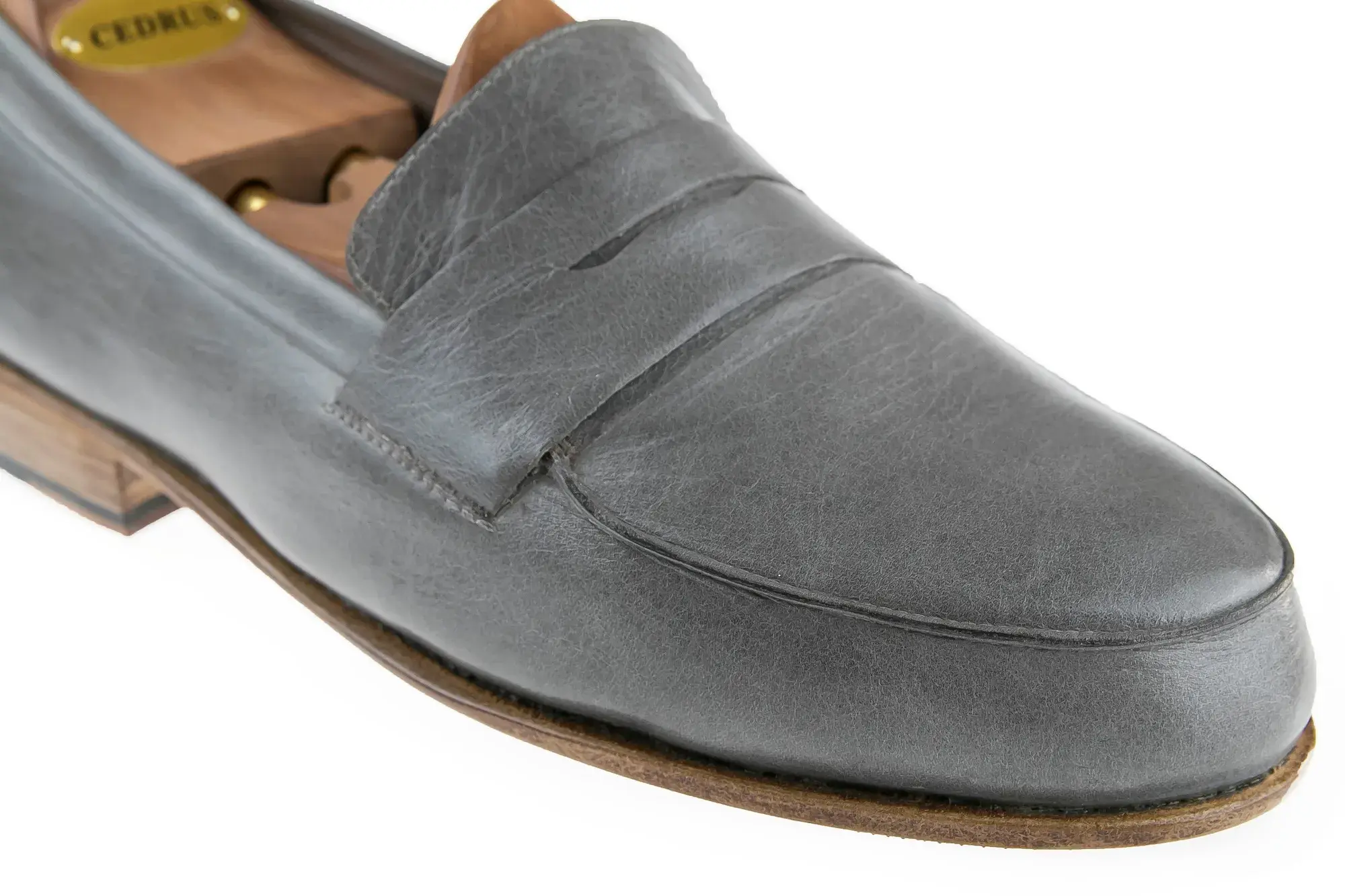 Vamp detail of a grey penny loafer
