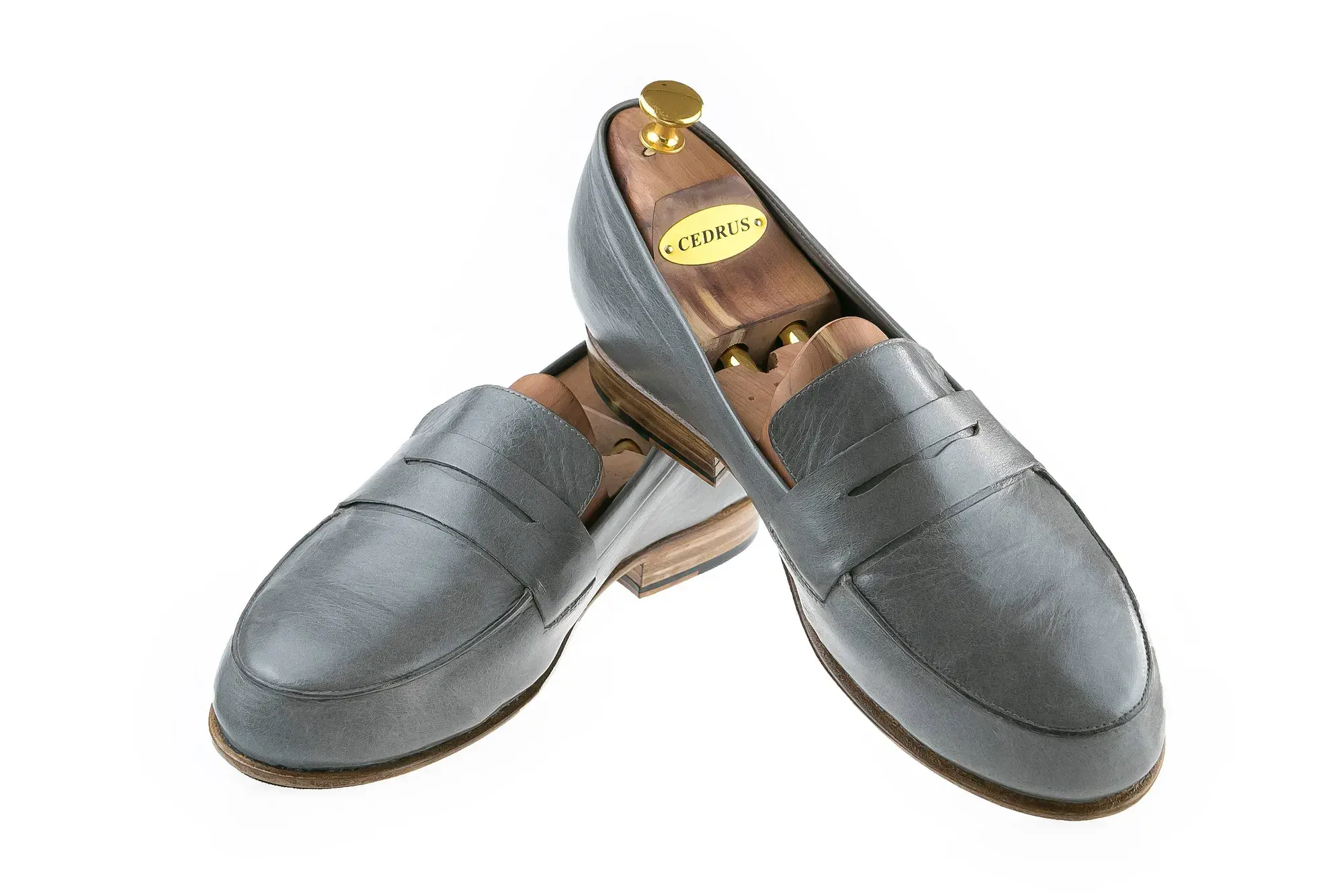 Grey Penny Loafers, one resting across the other