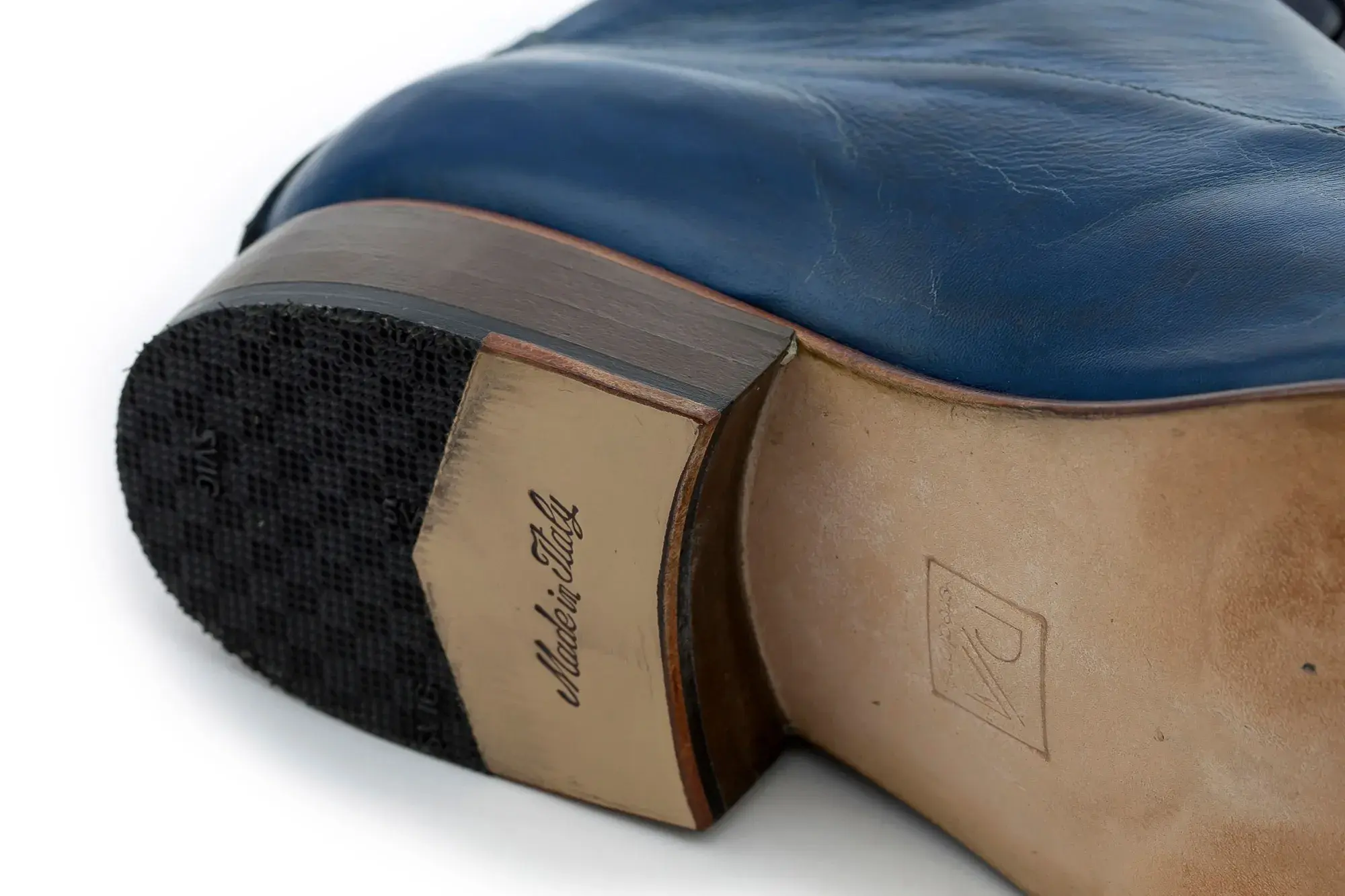 The sole of a navy capped boot, stamped with the maker's mark