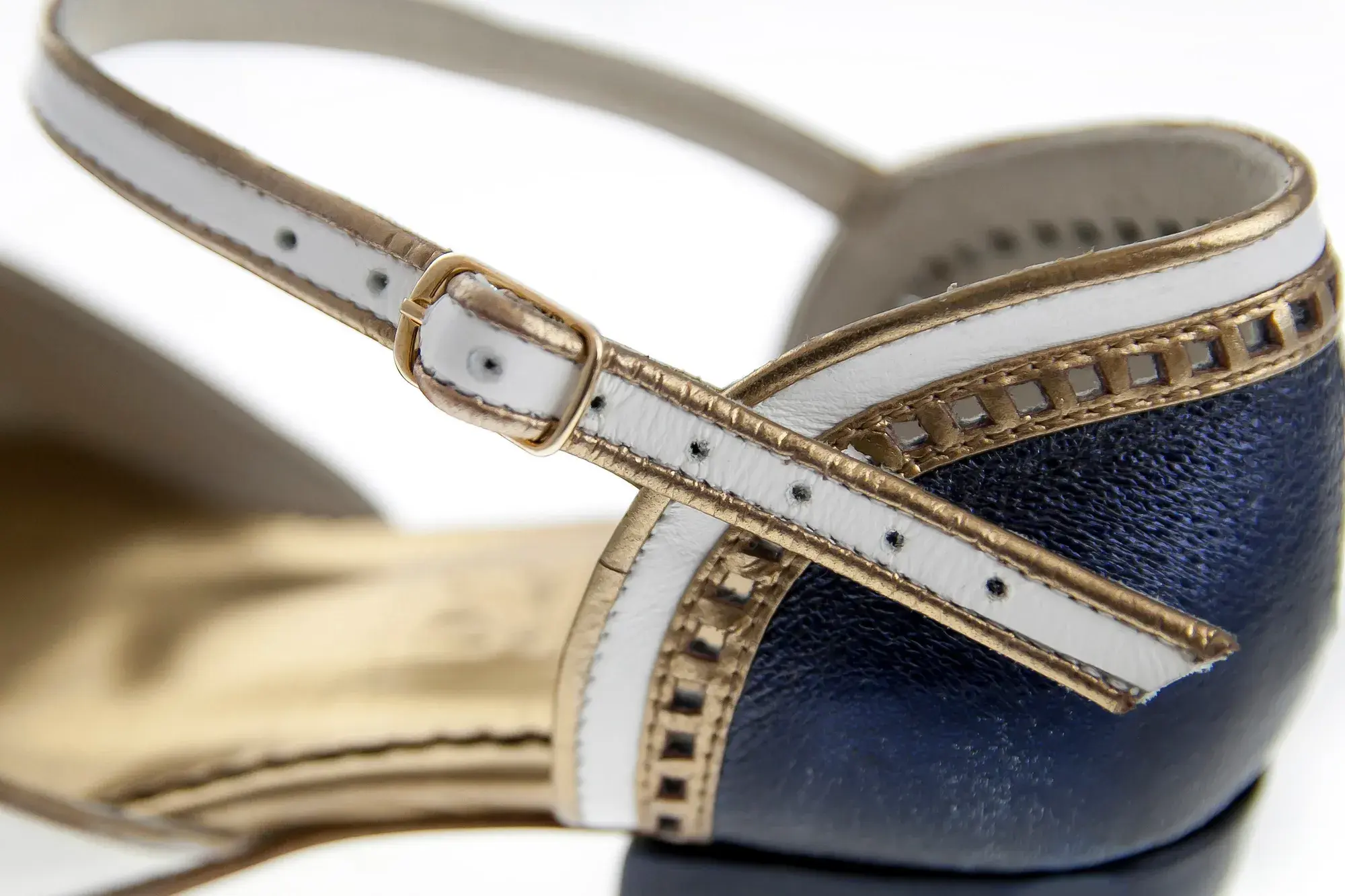 Buckle detail of a navy, white and gold Mary Jane