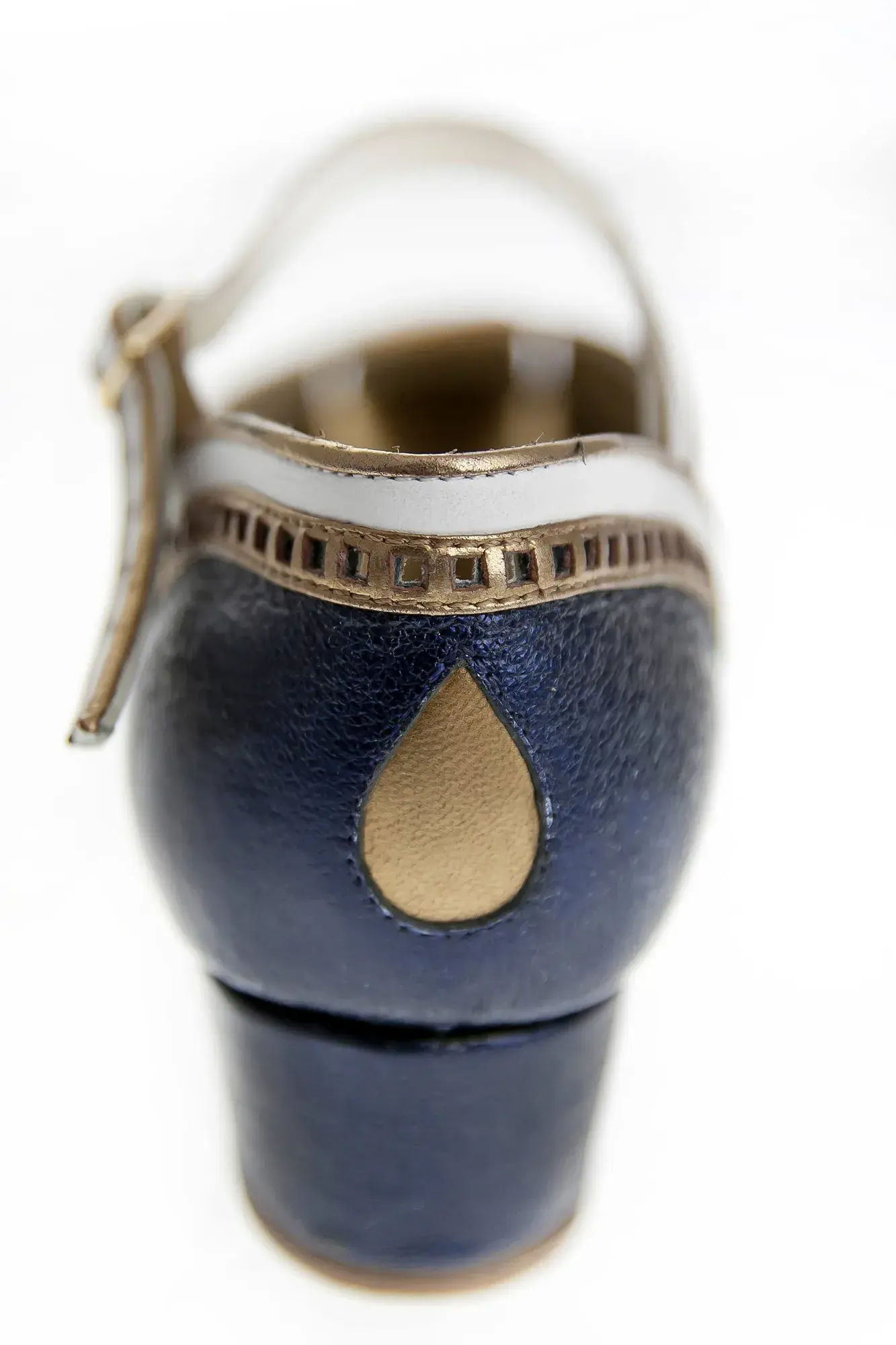 Heel detail of a navy, white and gold Mary Jane