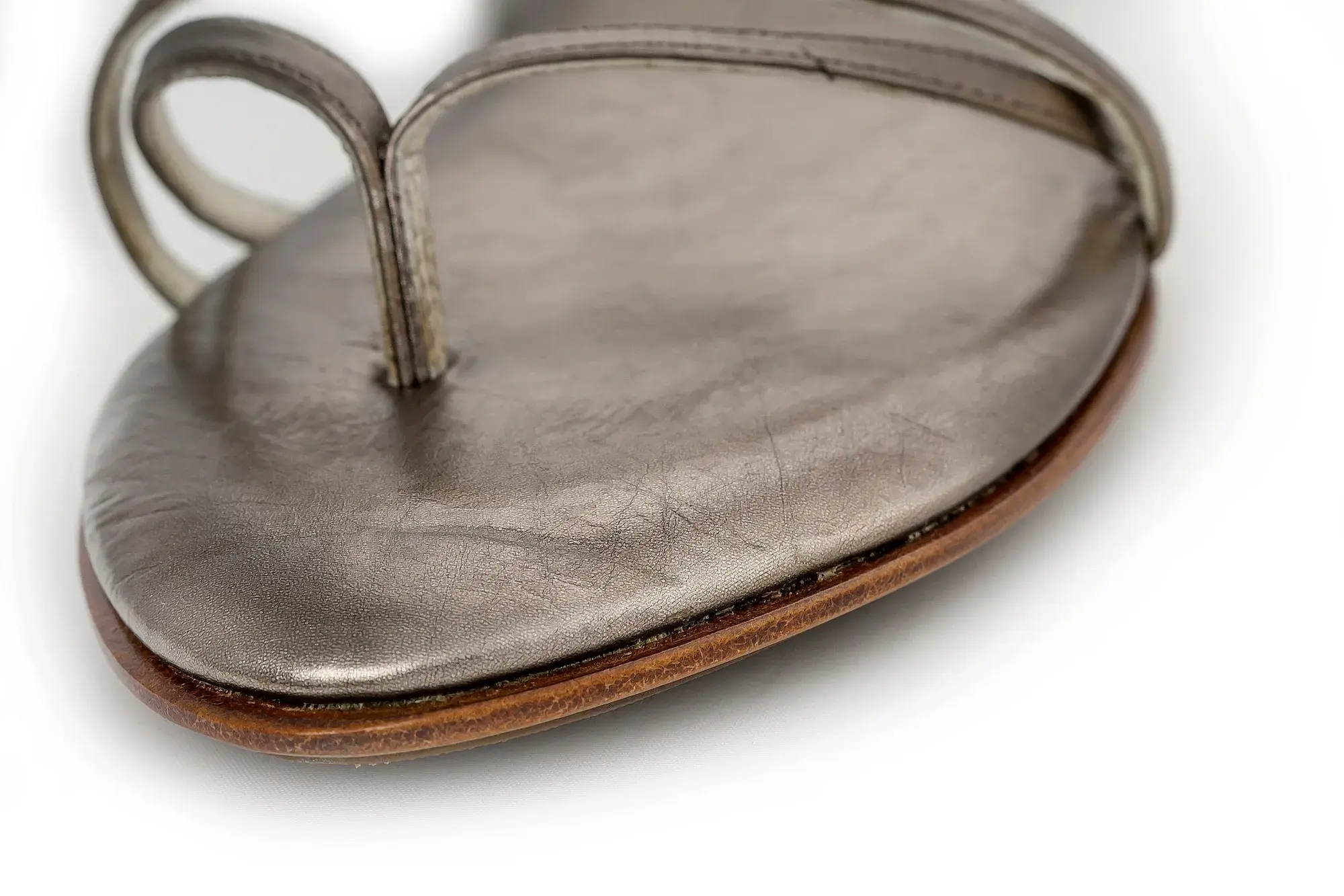 Toe loop detail of a pewter sandal