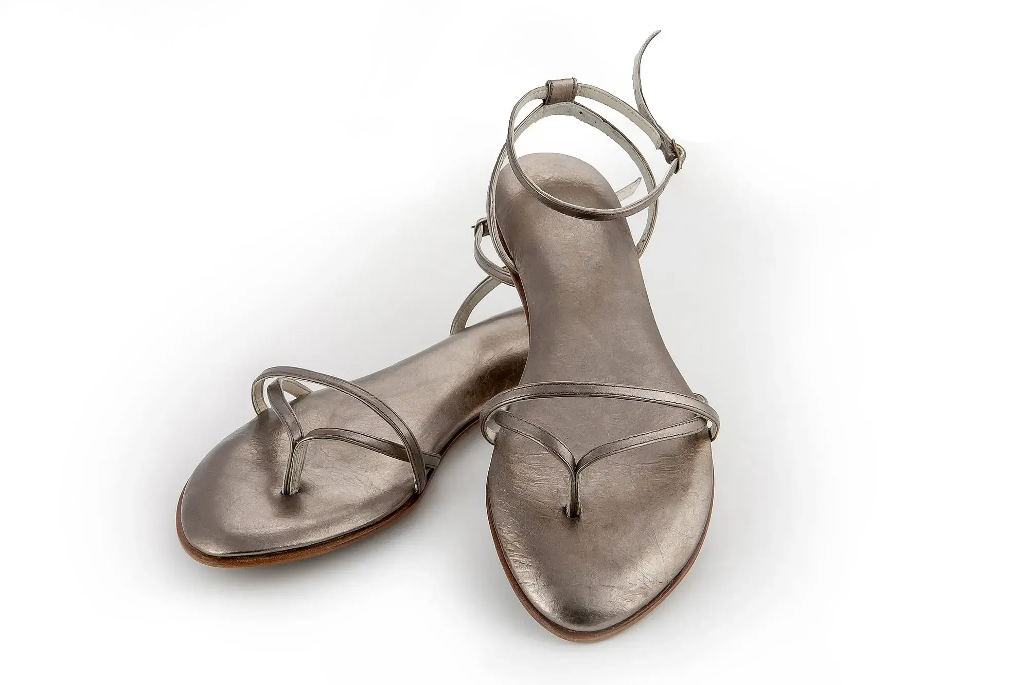 Pewter Sandals, one resting across the other