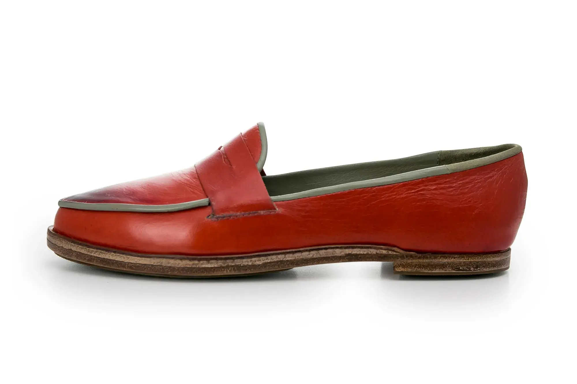 A red penny loafer in profile