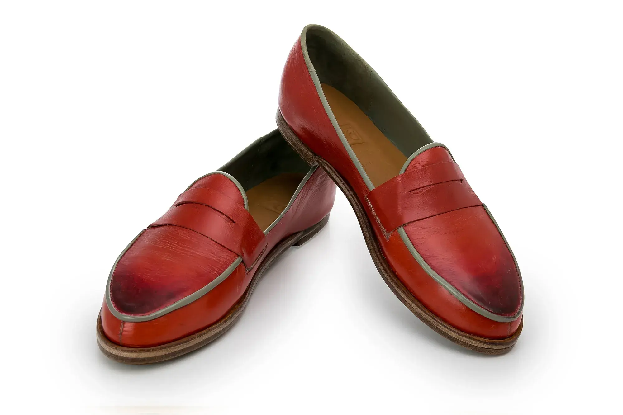 Red Penny Loafers, one resting across the other