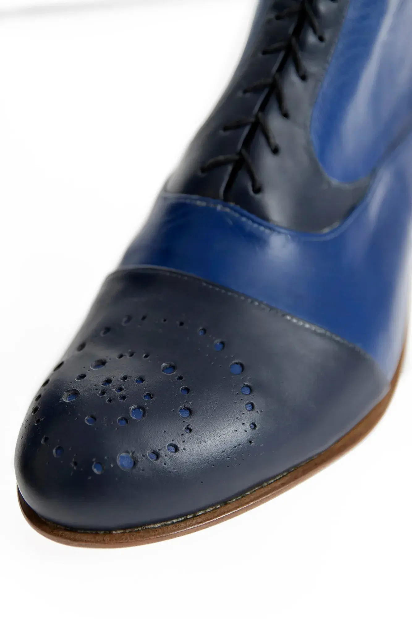 Toe brogue detail of a royal blue and navy boot