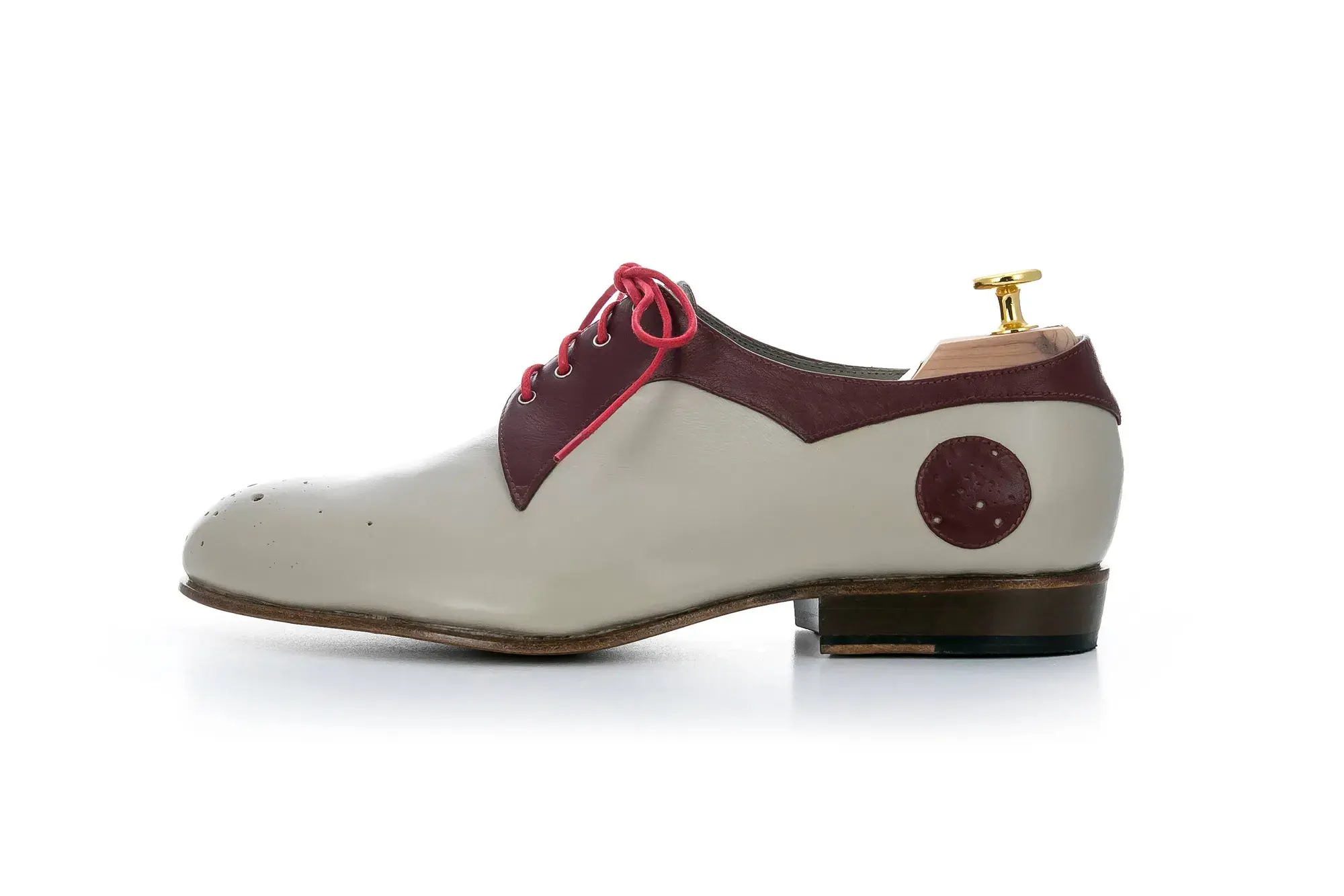 A stone and burgundy derby in profile