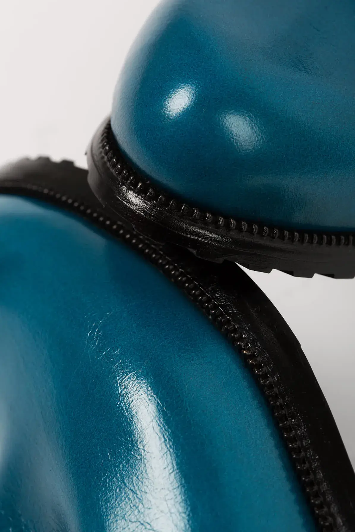 The toe and sole edge of a teal lace-up, close up