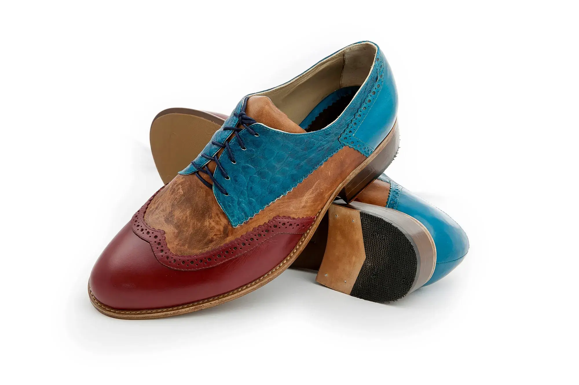 Teal, Tan and Burgundy Brogues, one resting across the other