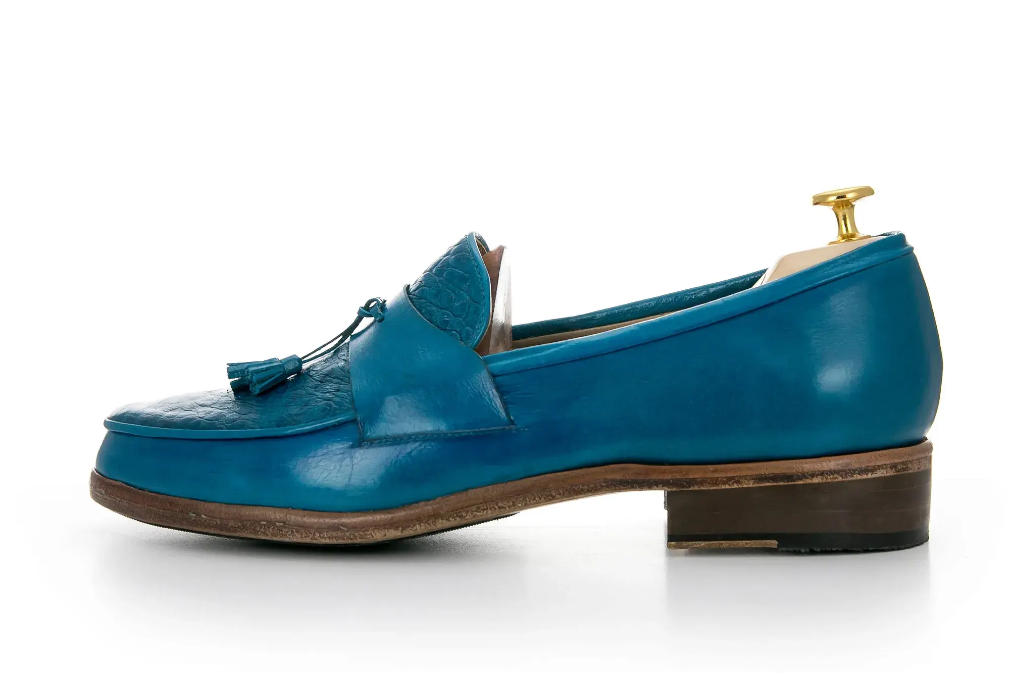 A turquoise tassel loafer in profile