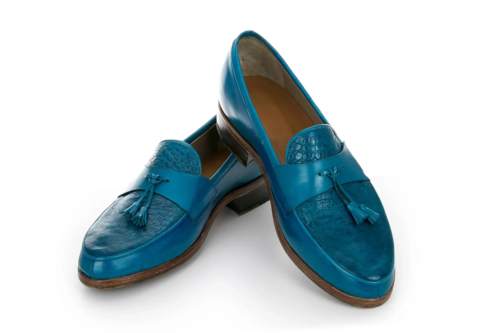 A turquoise tassel loafer seen from the side