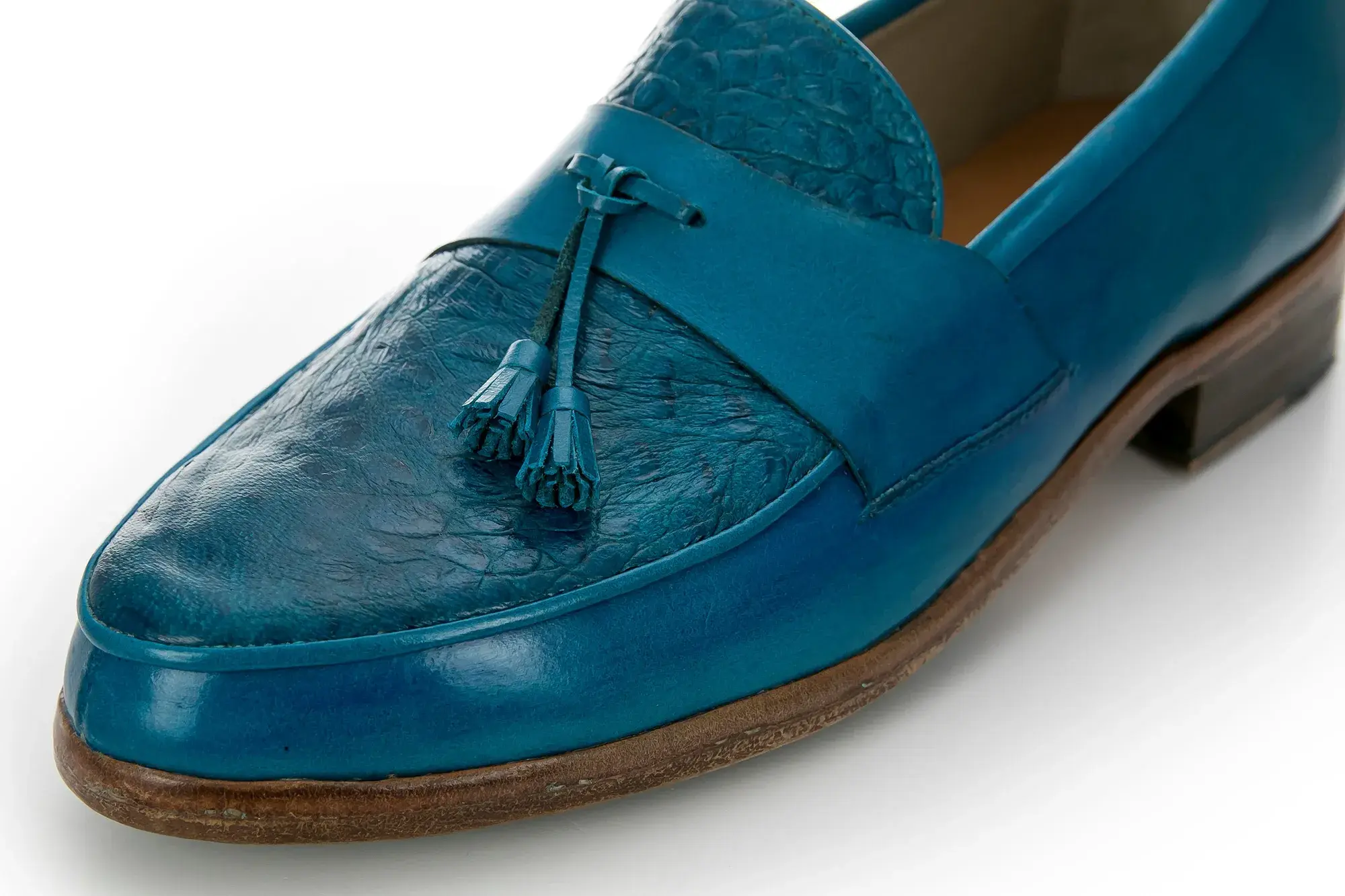 Vamp detail of a turquoise tassel loafer
