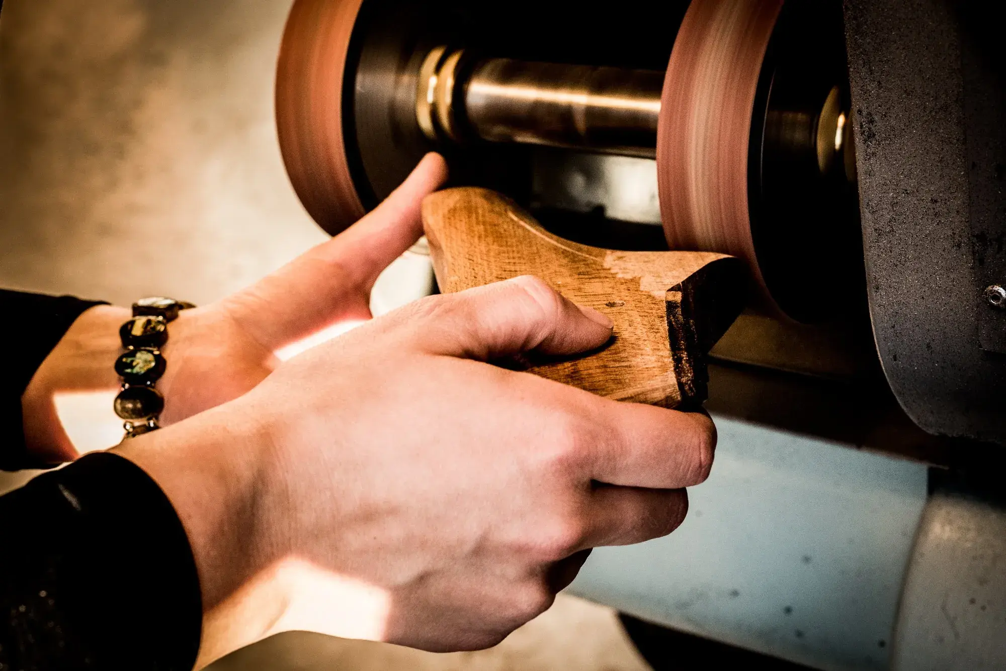 The heel of a wooden last being sanded on the wheel