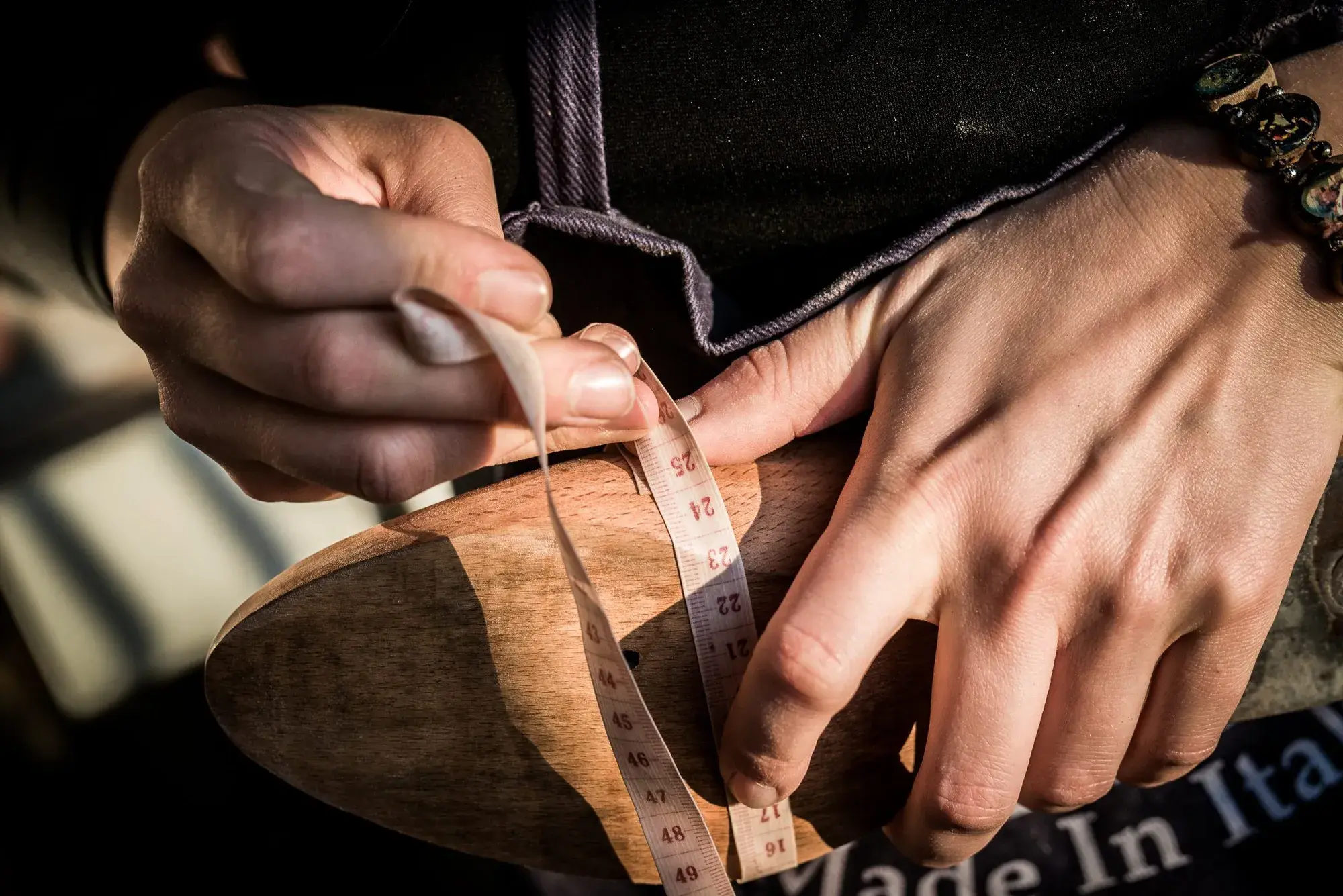 A tape measure wrapped around a wooden last