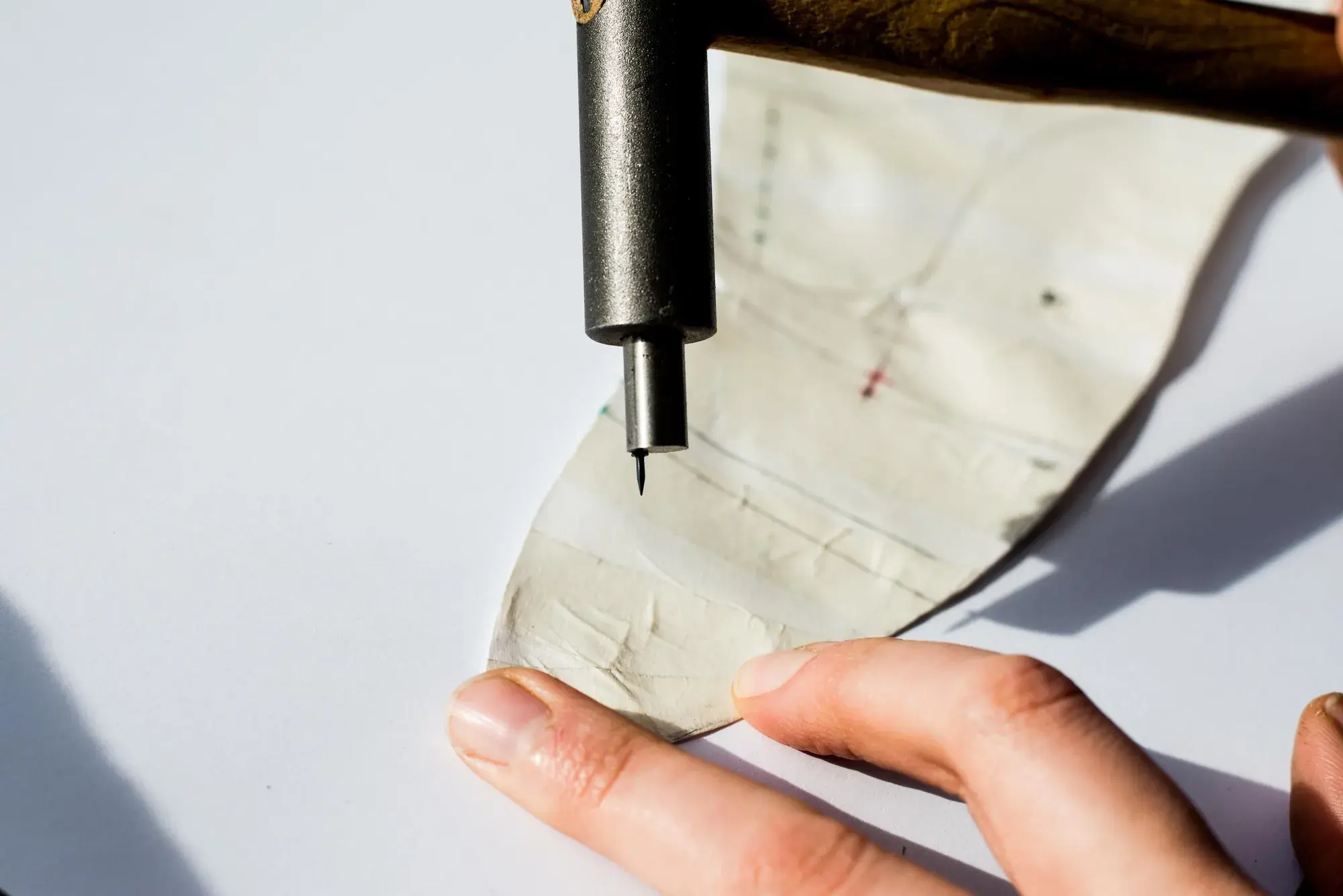 A pen marking a point through the tape pattern, close up