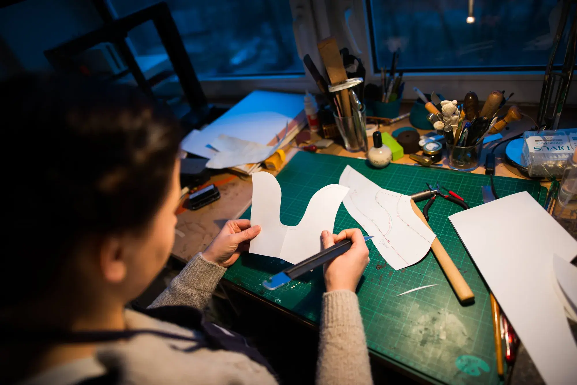 Overhead view of paper pattern pieces on the bench