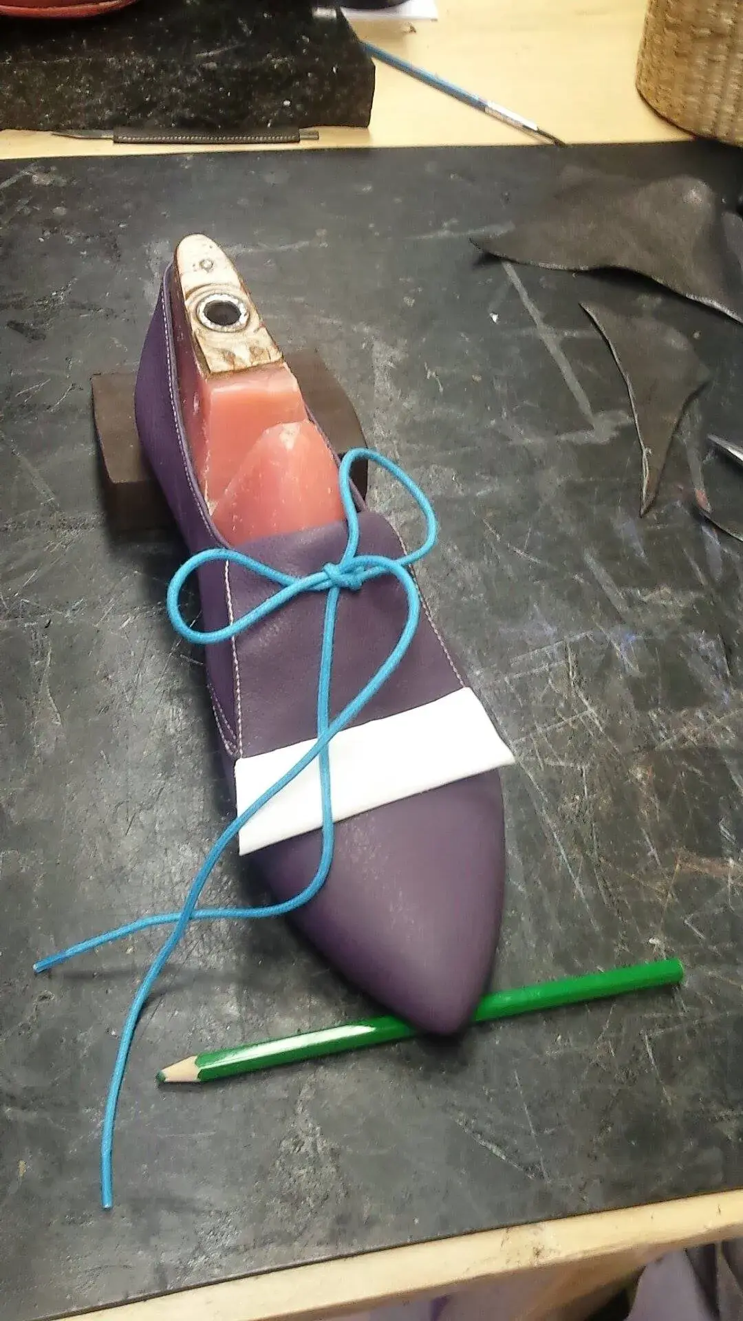 A purple mock-up upper laced over a last with blue string