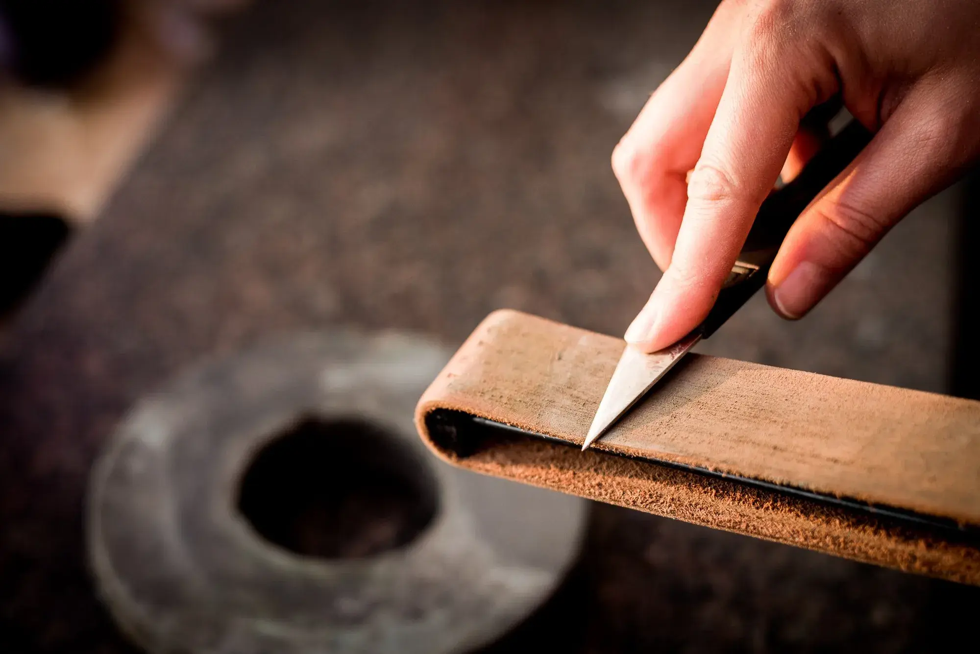 A knife being stropped on a leather strop