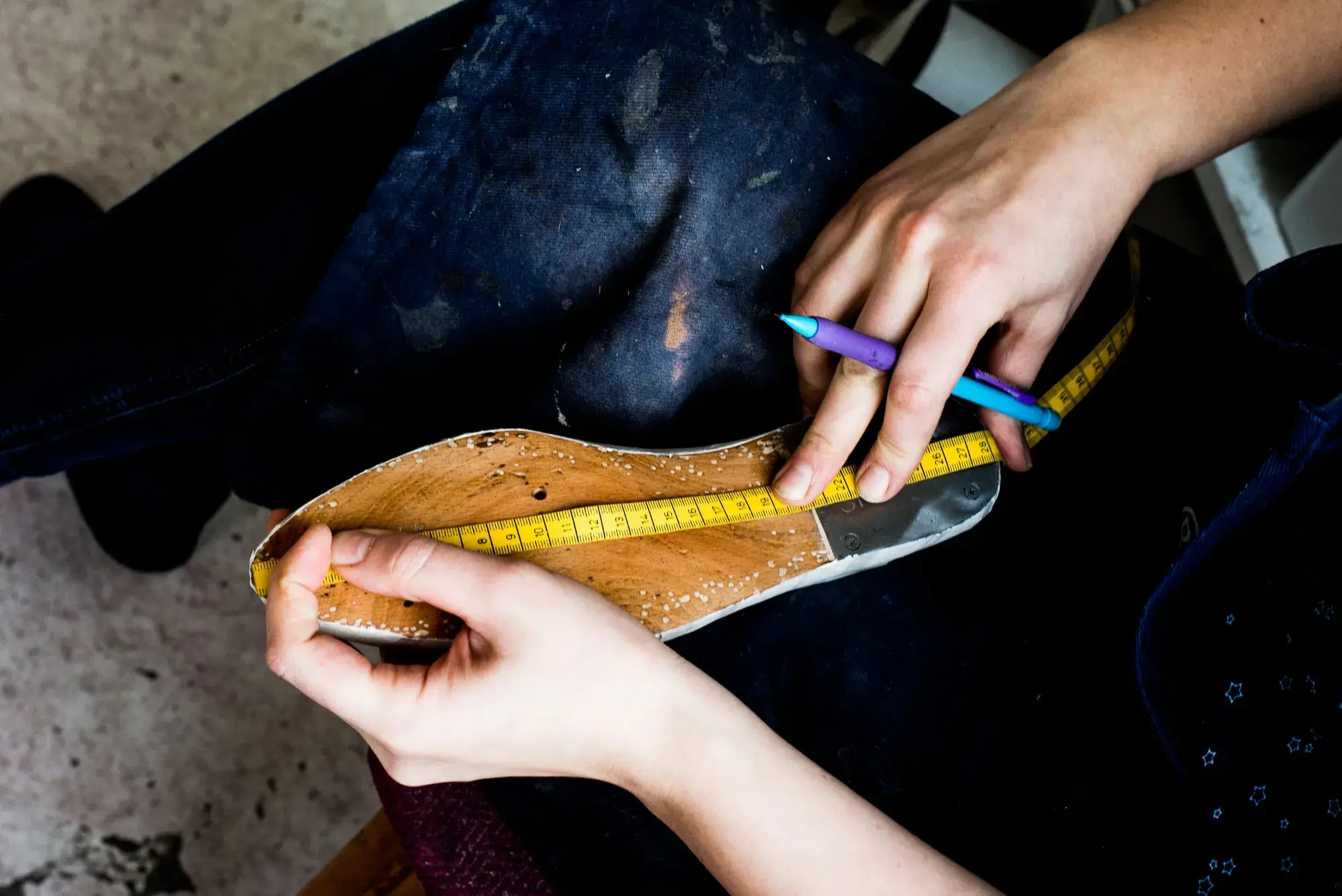 A tape measure laid along a leather insole