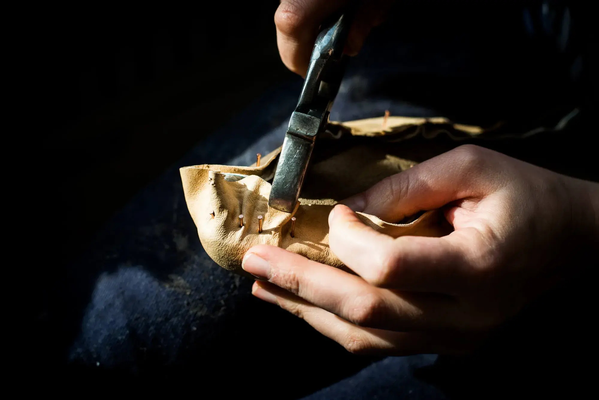 Lasting pincers pulling the leather upper over the last
