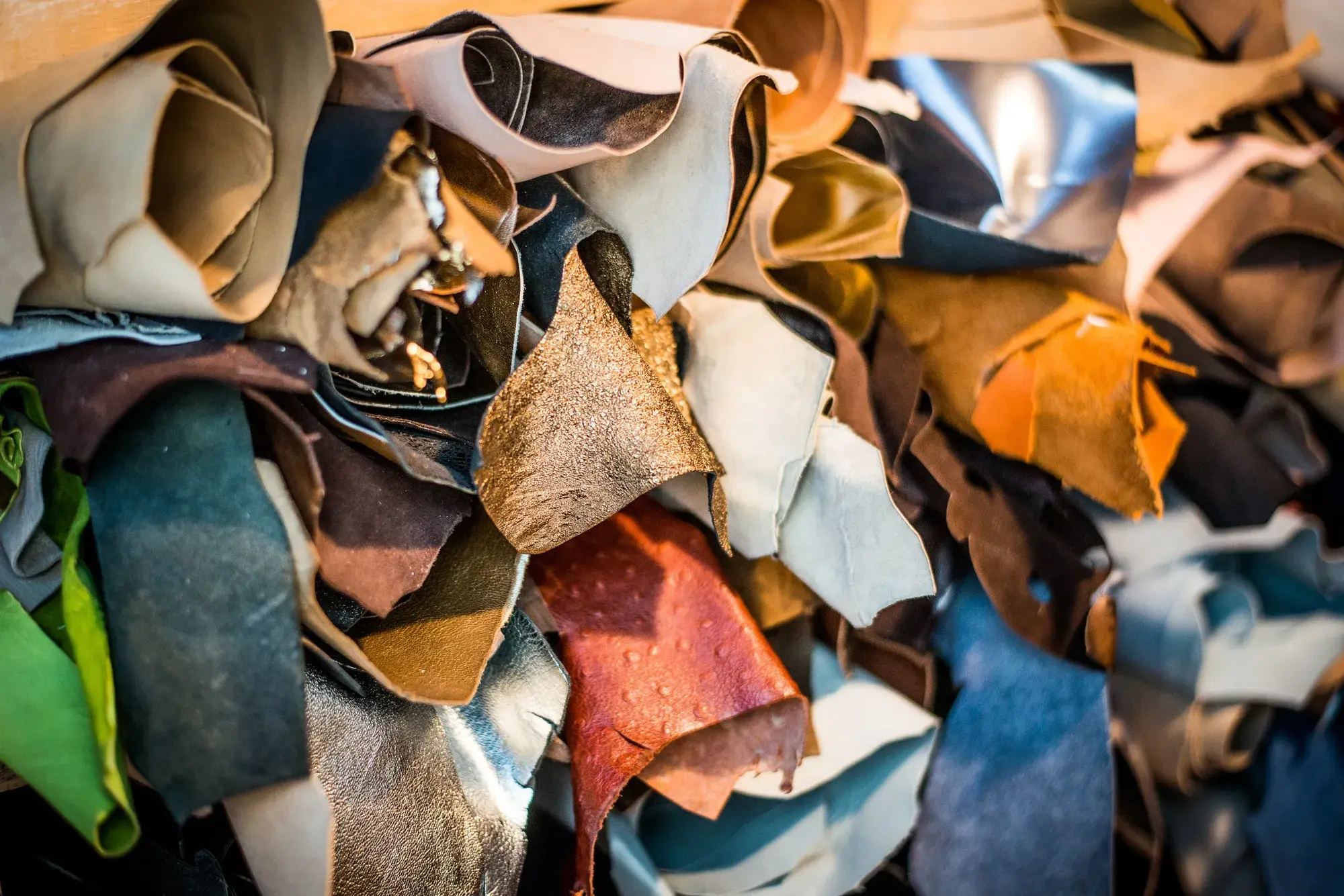 A pile of leather offcuts in many colours and finishes