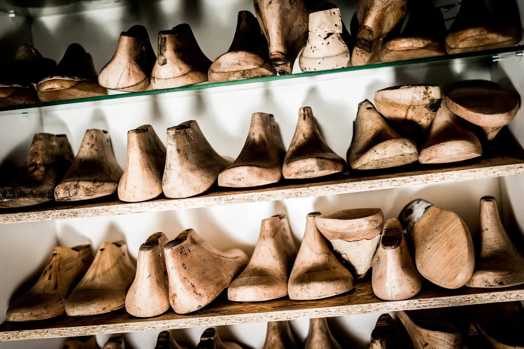 Rows of wooden lasts on the workshop shelves